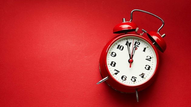 Vintage Alarm Clock On Red Background.