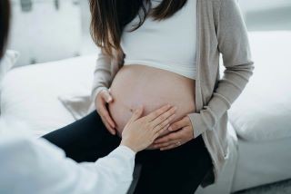 Picture of pregnant woman touching her stomach