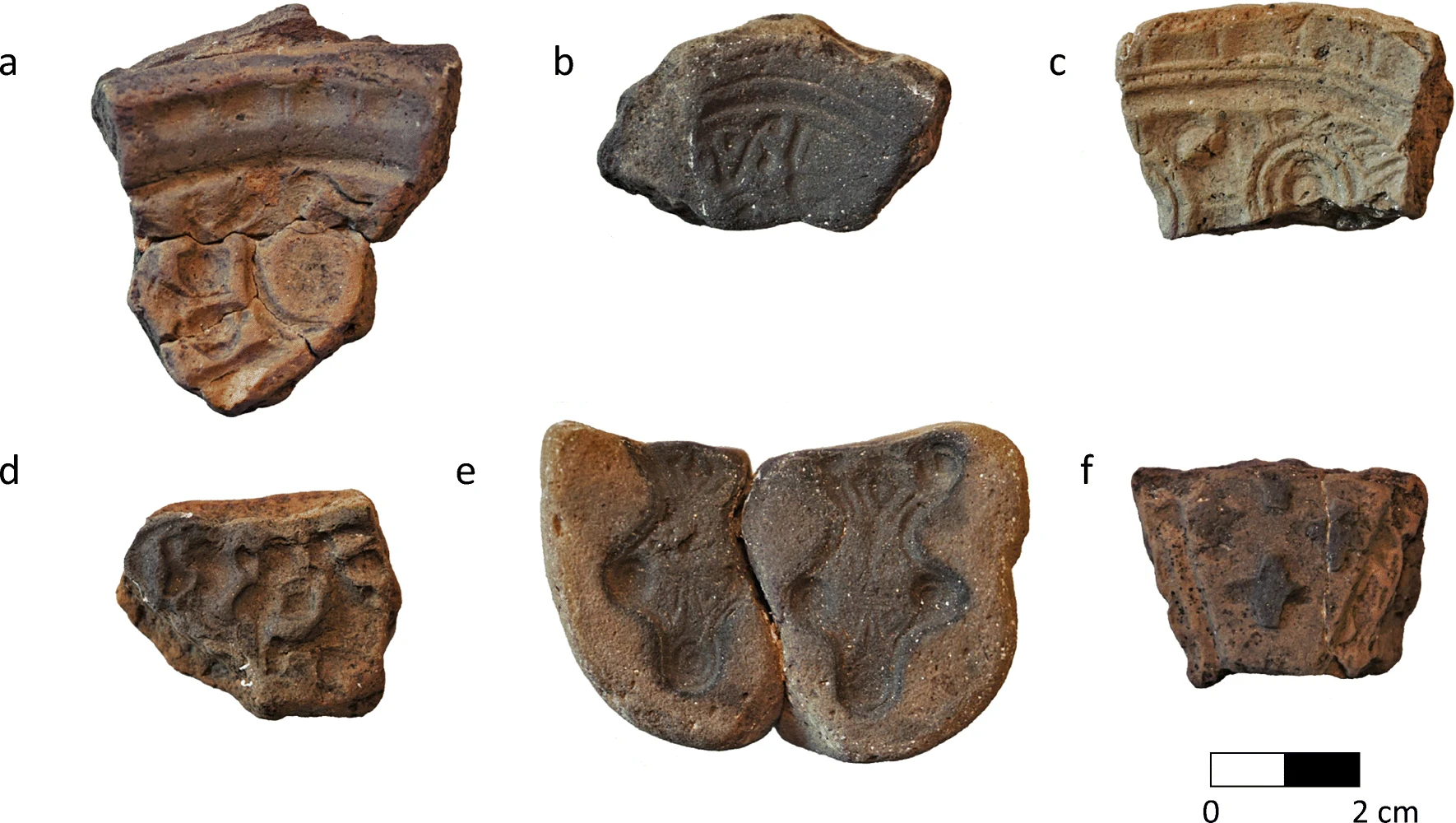 Metallhandwerk der Wikinger: Fotografie von Gussformen des Fundplatzes ASR9. Die Fragmente enthalten Abdrücke von ovalen, gleicharmigen Broschen und eines Schlüsselgriffs. 