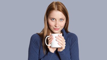 Junge Frau trinkt Kaffee (Symbolbild)