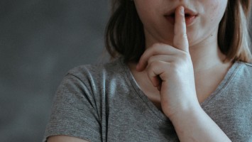 Mädchen legt Finger vor den Mund