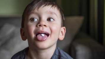 Junge mit Pille im Mund