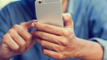 Mann tippt auf Smartphone