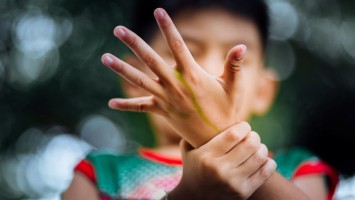 Junge umfasst sein Handgelenk