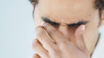 Mann hält sich die Augen