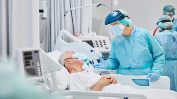 Ärztin spricht mit älterem COVID-19-Patienten