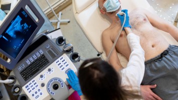 Ärztin führt Ultaschalluntersuchung der Schilddrüse aus