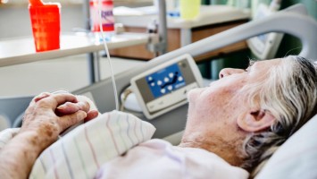 Seniorin liegt im Krankenhausbett