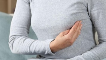 Frau tastet ihre Brust ab