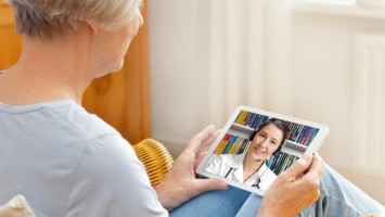 Ältere Frau hält Tablet in den Händen