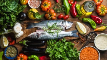 Holztisch mit Gemüse, Obst und Fisch