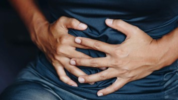 Person hält sich den Bauch