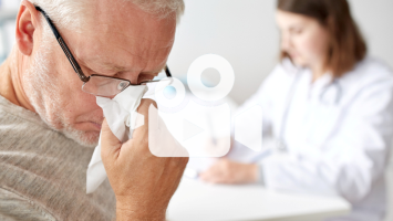 Senior mit Schnupfen bei Ärztin