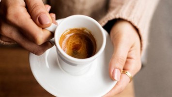 Frau hält Espressotasse