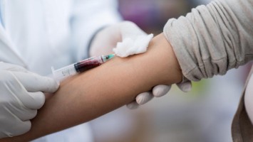 Frau wird Blut abgenommen