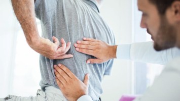 Arzt untersucht Patient mit Rückenschmerzen