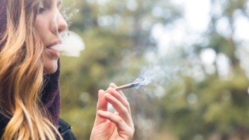 Junge Frau raucht Joint 