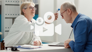 Ärztin misst Fieber bei älterem Patienten