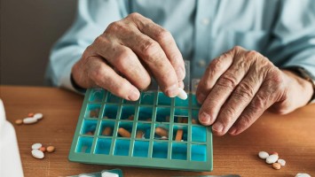 Ältere Person sortiert Medikamente