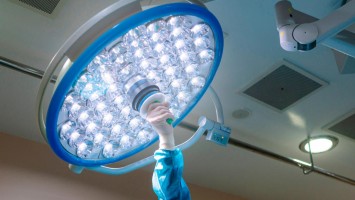 Hand an einer Lampe im Operationssaal