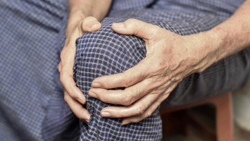 Ältere Person hält sich das Knie