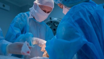 Eine Ärztin und ein Arzt während Operation