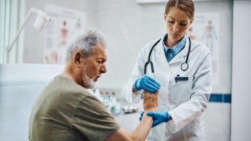 Ärztin untersucht älteren Mann