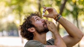 Mann benutzt Augentropfen