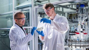 Litona founder Sebastian Büchele shows a bottle of the energy storage material Prussian white for sodium-ion batteries.