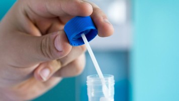 Hand hält Laborröhrchen