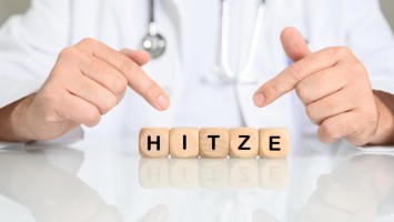 Arzthände zeigen auf Hitzebuchstaben