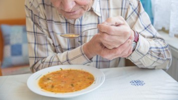 Senior hält mit beiden Händen Löffel