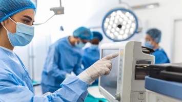 Anästhesistin kontrolliert Monitor im OP
