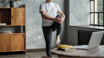 Mann steht auf einem Bein