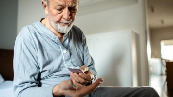 Älterer Mann mit Tabletten in der Hand