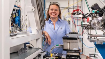 Eine braunhaarige Frau mit hellblauer Bluse zwischen technischen Gerätschaften. 