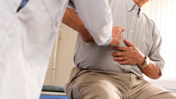 Patient mit Bauchschmerzen beim Arzt