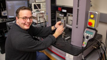 A young man is operating a machine.