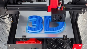 Red and black 3D printer prints blue logo symbol on metal diamond plate.