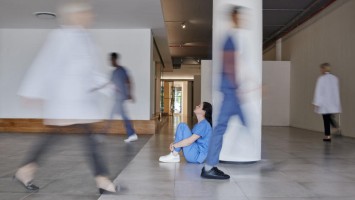 Junge Frau sitzt in der Klinik auf dem Boden