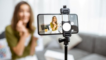 Frau zeichnet ein Video von sich mit den Handy auf