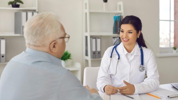 Ärztin erklärt älterem Patienten seine Diagnose