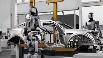 Zwei humanoide Roboter arbeiten an einer Karosserie. 