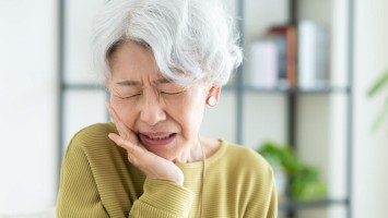 Frau mit starken Gesichtsschmerzen