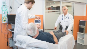 Senior auf Trage spricht mit Arzt und Pfleger