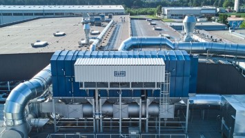 Industrieanlage, bewaldete Berge im Hintergrund