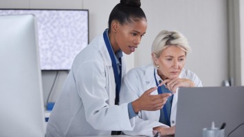 Zwei Ärztinnen schauen in Laptopbildschirm