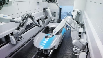 Mehrere Roboterarme lackieren eine Auto-Karossierie