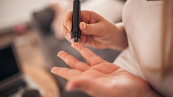 Eine schwangere Frau misst ihren Blutzucker