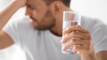 Junger Mann trinkt Wasser